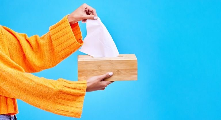 Woman's hands removing a tissue from it's container
