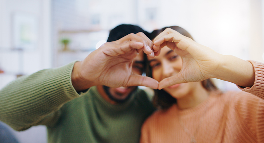 Young couple a heart gesture with each other's hands